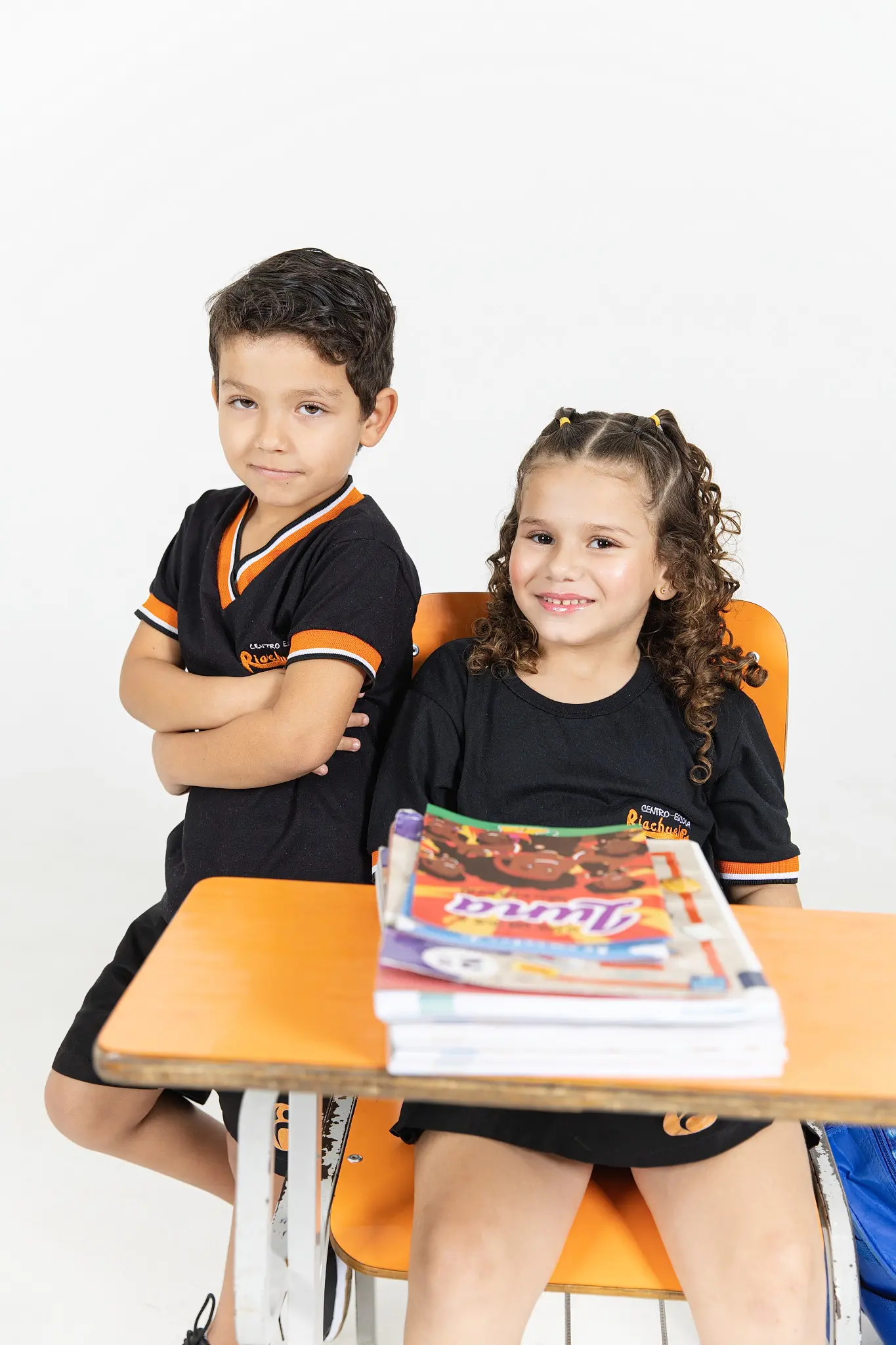 Dois amigos na carteira com os livros da Turma do Nick