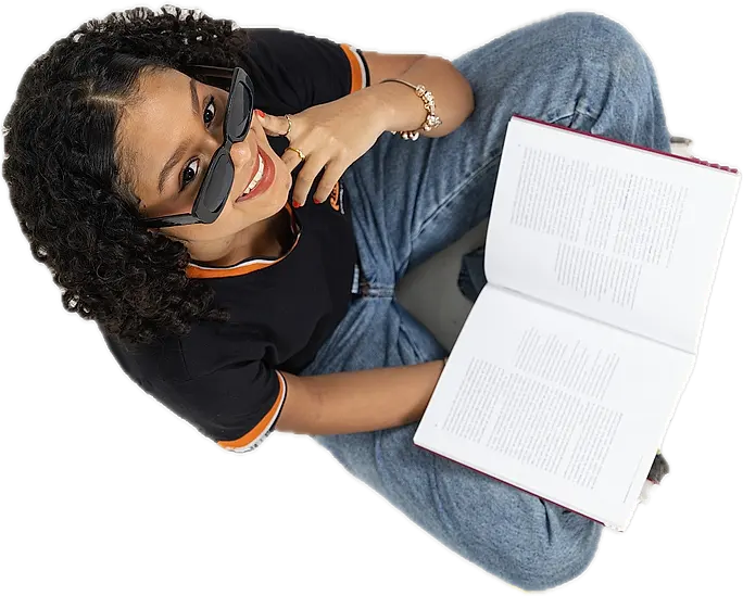 Aluna de óculos escuros lendo um livro aberto